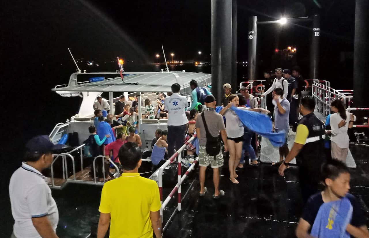 นักท่องเที่ยวจากเรือที่ล่มลงลำหนึ่งได้ครับความช่วยเหลือบริเวณท่าเรือ (Image: Royal Thai Police)