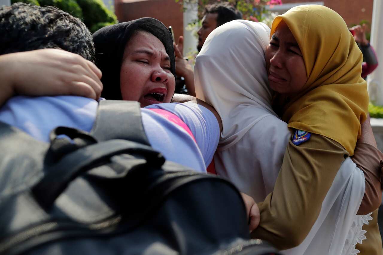 Indonesian relatives of the plane crash victims cry as they wait for the news at the airport in Sukarno Hatta Airport, Indonesia.