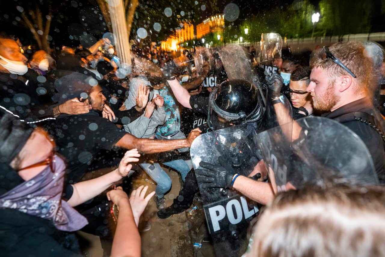 US Secret Service form a line outside the White House as protestors attempt to breach their barricade