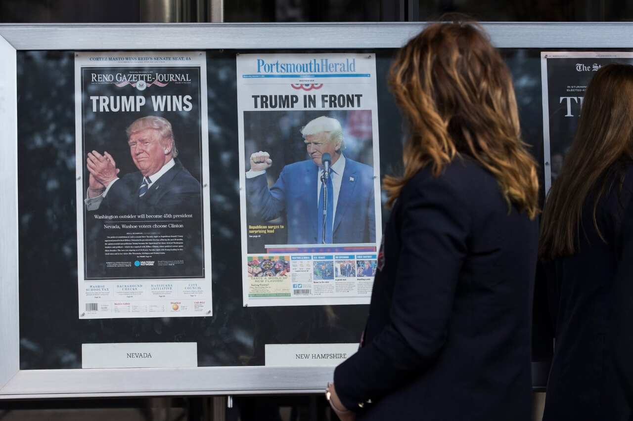 Students look at election coverage on the front pages of today's Reno Gazette-Journal and Porthsmouth Herald in Washington, DC (AAP)