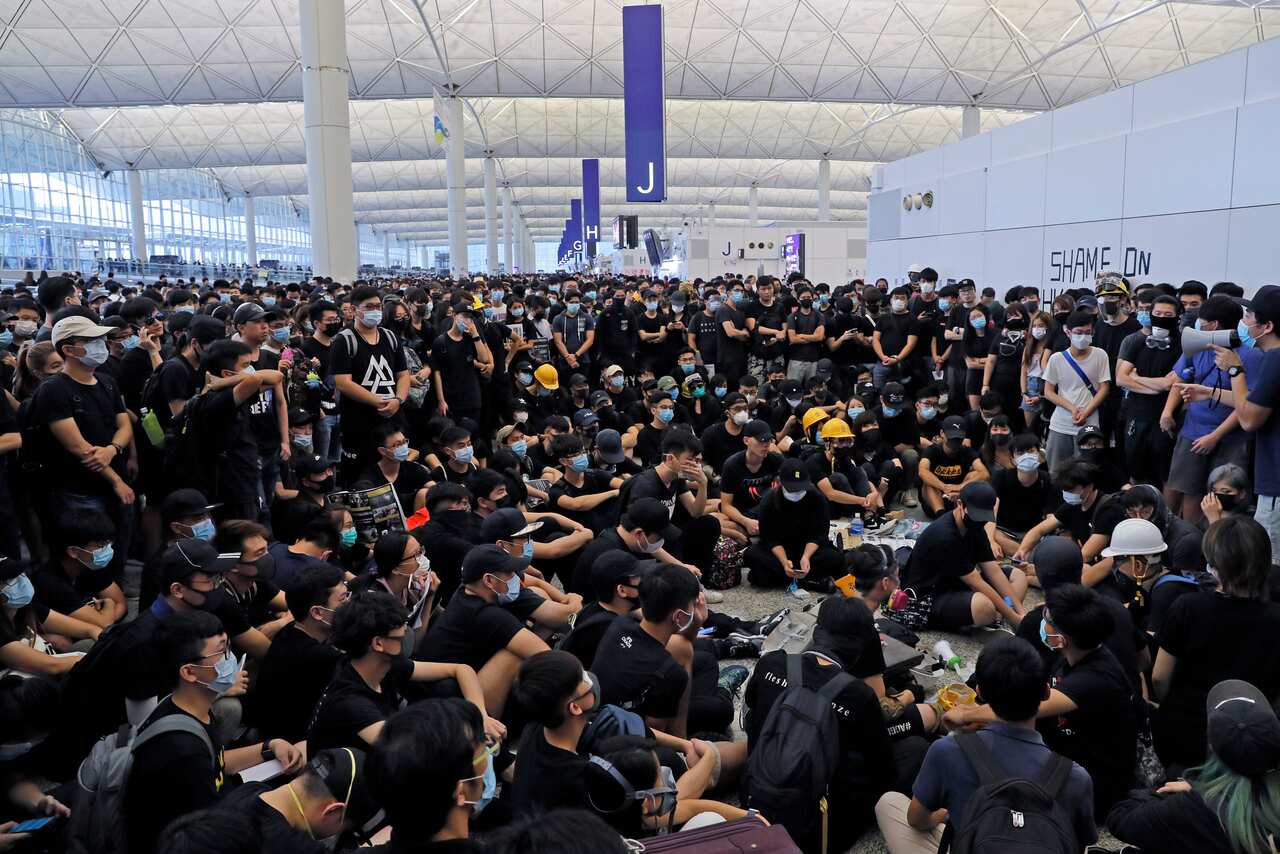 Protesters gather near an information board during the protest at the Hong Kong International Airport.