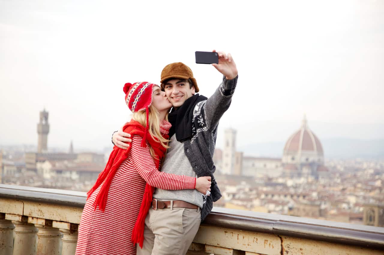 A couple take a photo of themselves kissing