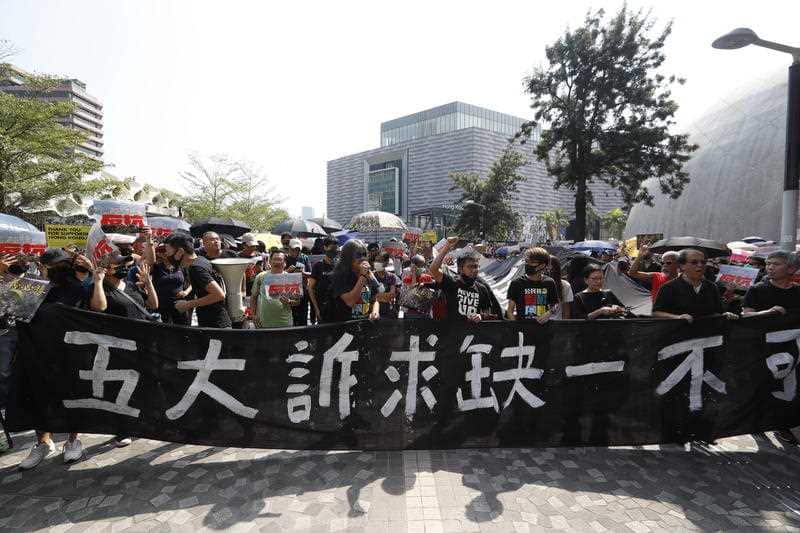 Protesters march during a rally in Hong Kong on Sunday