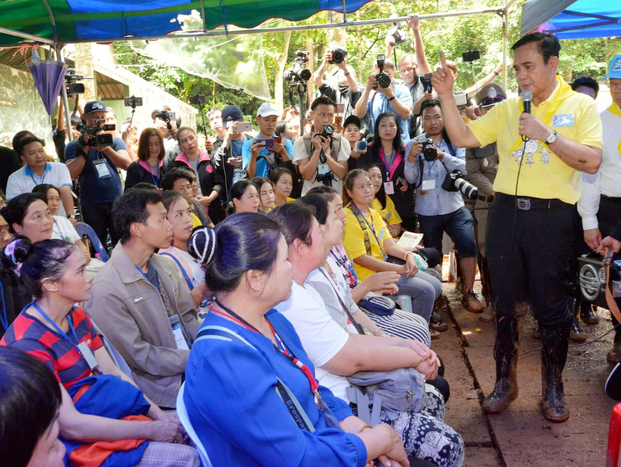 Thai Prime Minister Prayut Chan-o-cha (R) talks in Chiang Rai, northern Thailand, on June 29, 2018, to relatives of boys and their football coach who went missing after entering a cave nearby. (Kyodo via AP Images) ==Kyodo