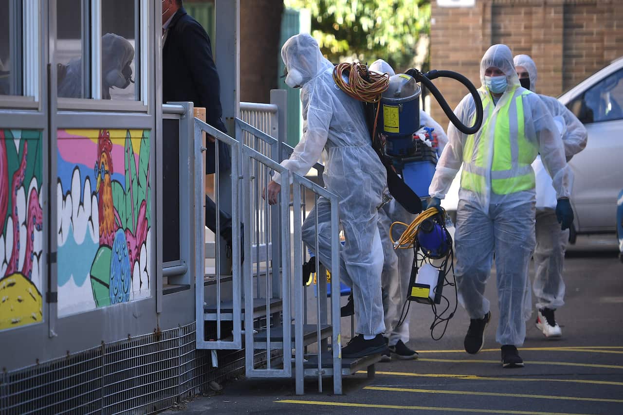 Cleaners at Bondi Beach public school, which is undergoing a deep clean after a student tested positive to COVID-19.