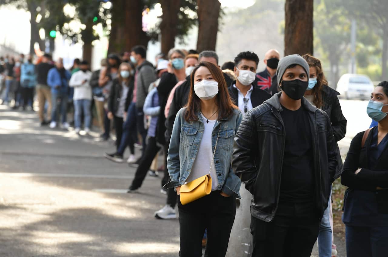 People are seen queued to receive their vaccination at the NSW Vaccine Centre at Homebush Olympic Park in Sydney.