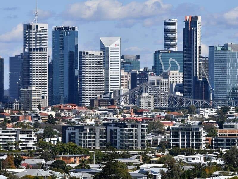 Houses and apartment buildings against the Brisbane CBD skyline.