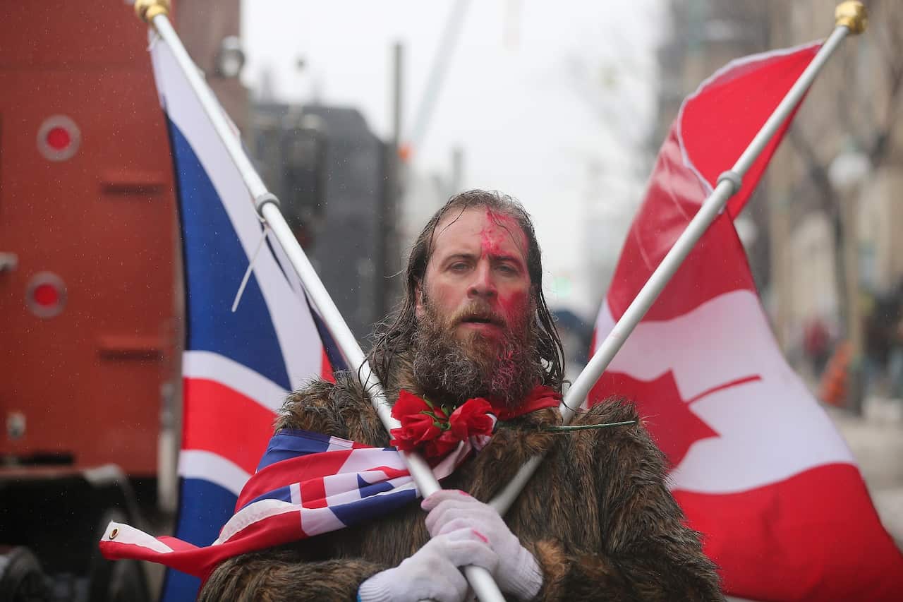 A protester yells freedom as he walks past Parliament Hill.