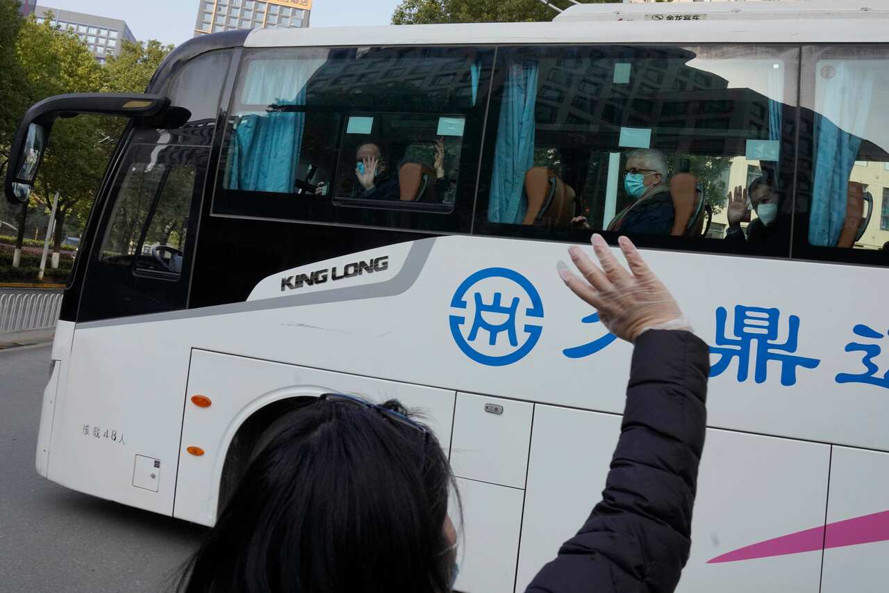 Workers wave off the team of experts from the World Health Organization as they left the quarantine in Wuhan on Thursday, 28 January.