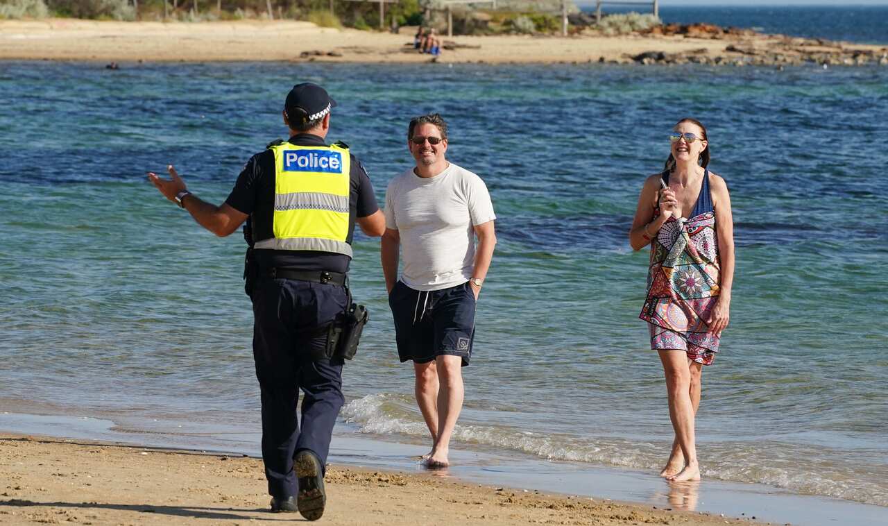 Victoria Police officers ask people to leave Melbourne's Brighton Beach.