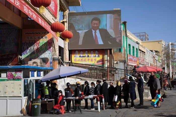 A screen shows Chinese President Xi Jinping in Hotan in western China's Xinjiang region.