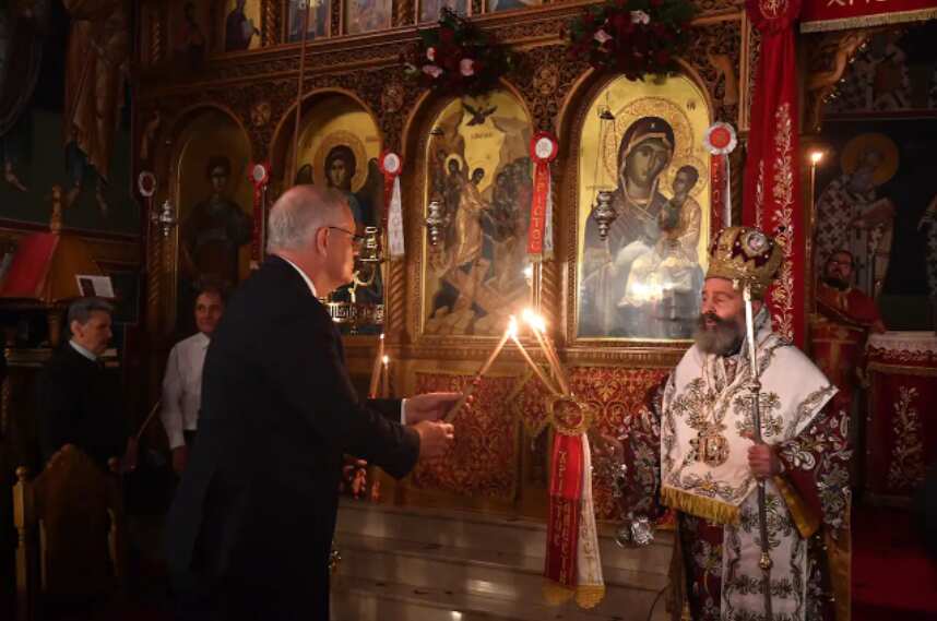 Prime Minister Scott Morrison lights his candle from Archbishop Makarios at the service held at the Greek Orthodox Church in Kogarah on 23 April 2022. 