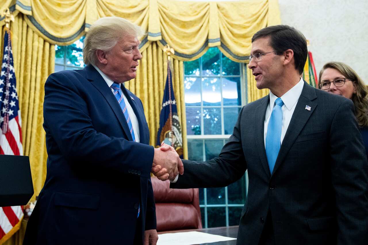 Mark Esper shakes Donald Trump's hand after being sworn-in as US Secretary of Defense in July 2019.