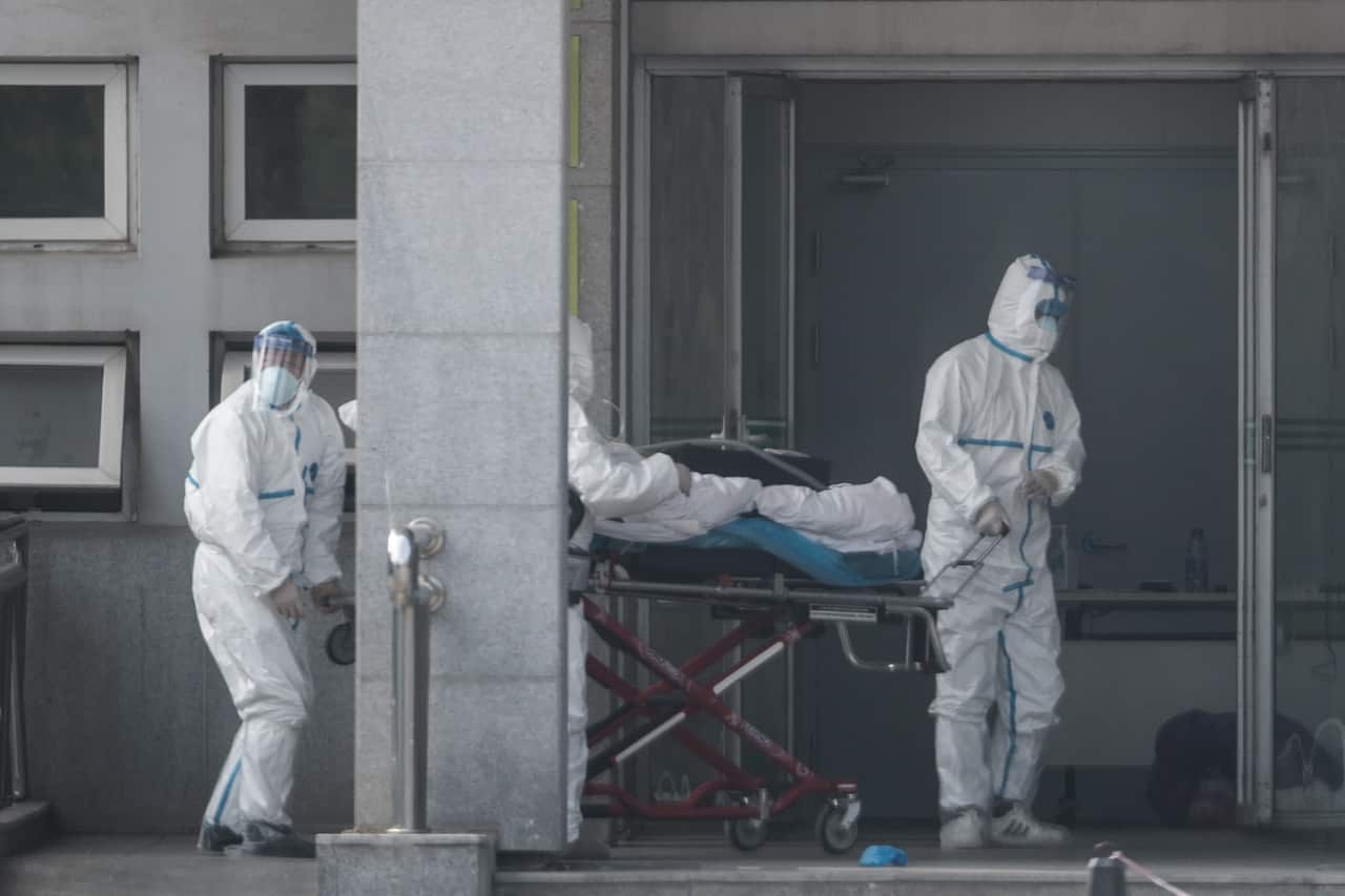 Medical staff carry a patient into the Jinyintan hospital in Wuhan, China, 18 January 2020 