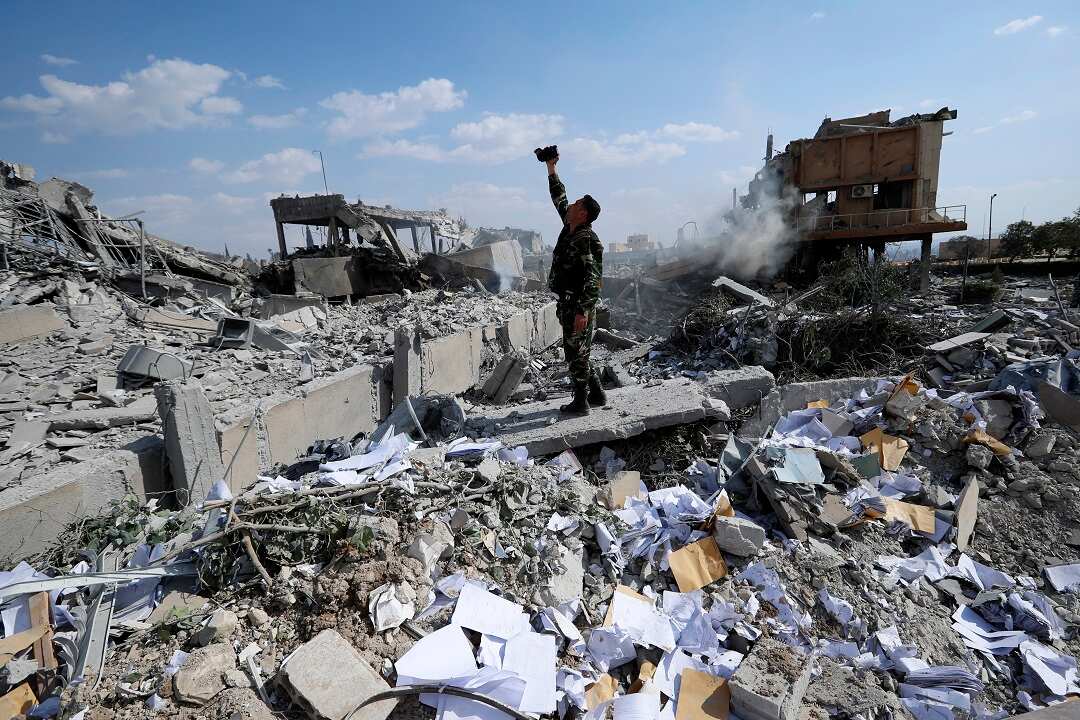 A Syrian soldier films the damage of the Syrian Scientific Research Center which was attacked by US., British and French military strikes.