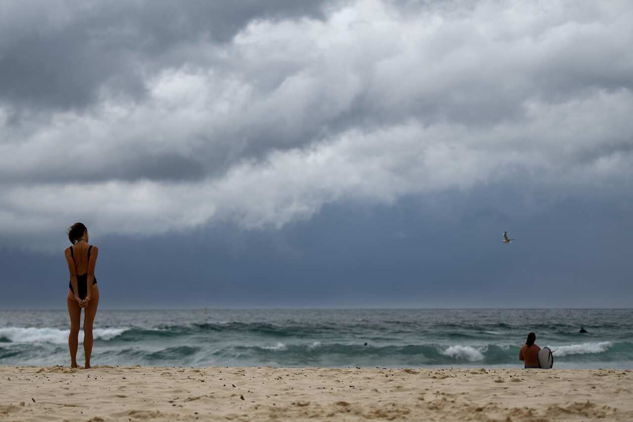 Swimmers observe the dark clouds gathering over Sydney's Bondi Beach.