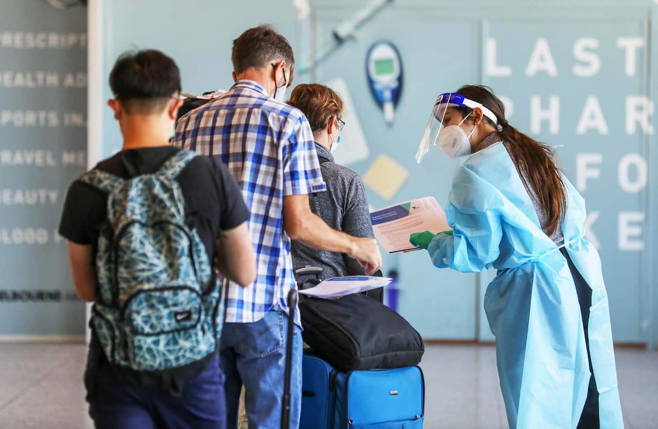 Passengers arriving from Sydney get tested for COVID- 19 at Melbourne Airport. 