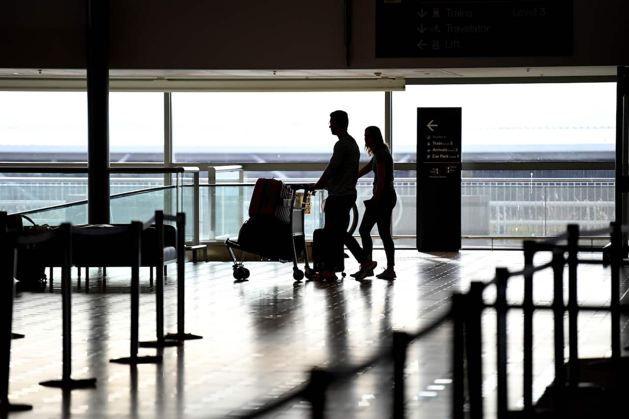 Travellers arrive to check in to one of only a handful of departing flights at the Brisbane international airport, Monday, March 30, 2020