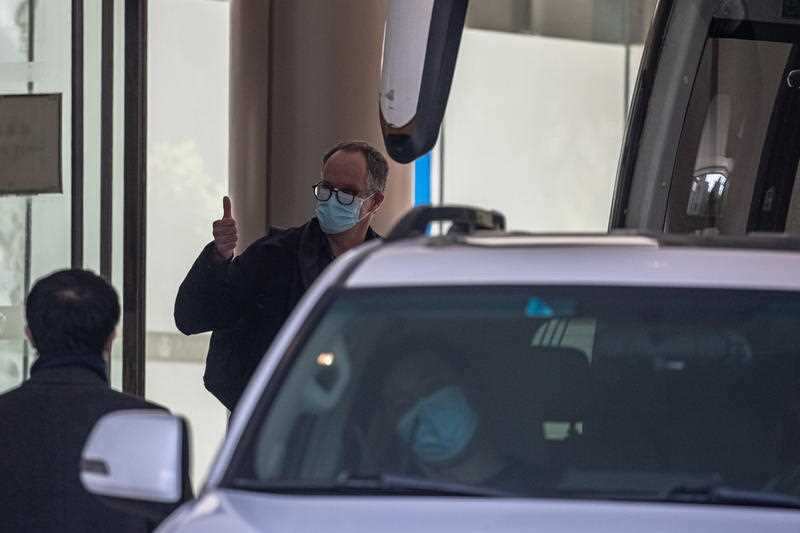 World Health Organisation officials leave hotel quarantine in Wuhan. 