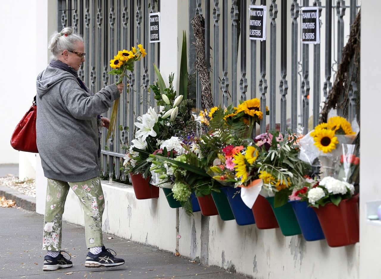 A woman prepares tp lay flowers outside the Al Noor Mosque in Christchurch.