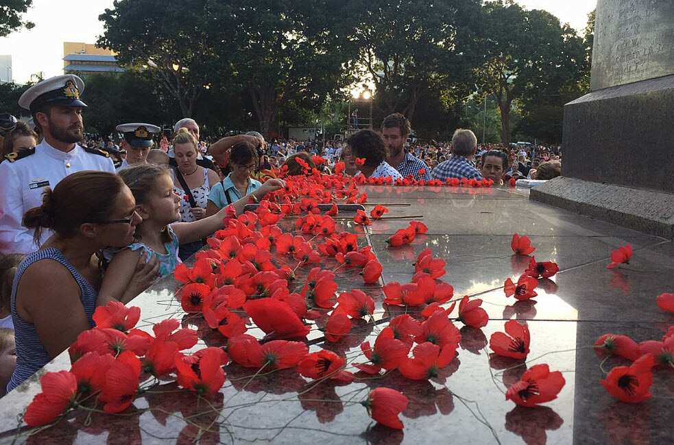 A young girl lays a poppy on the Darwin cenotaph following the Anzac Day dawn service at the Bicentennial Park in Darwin, Saturday, April 25, 2015. 