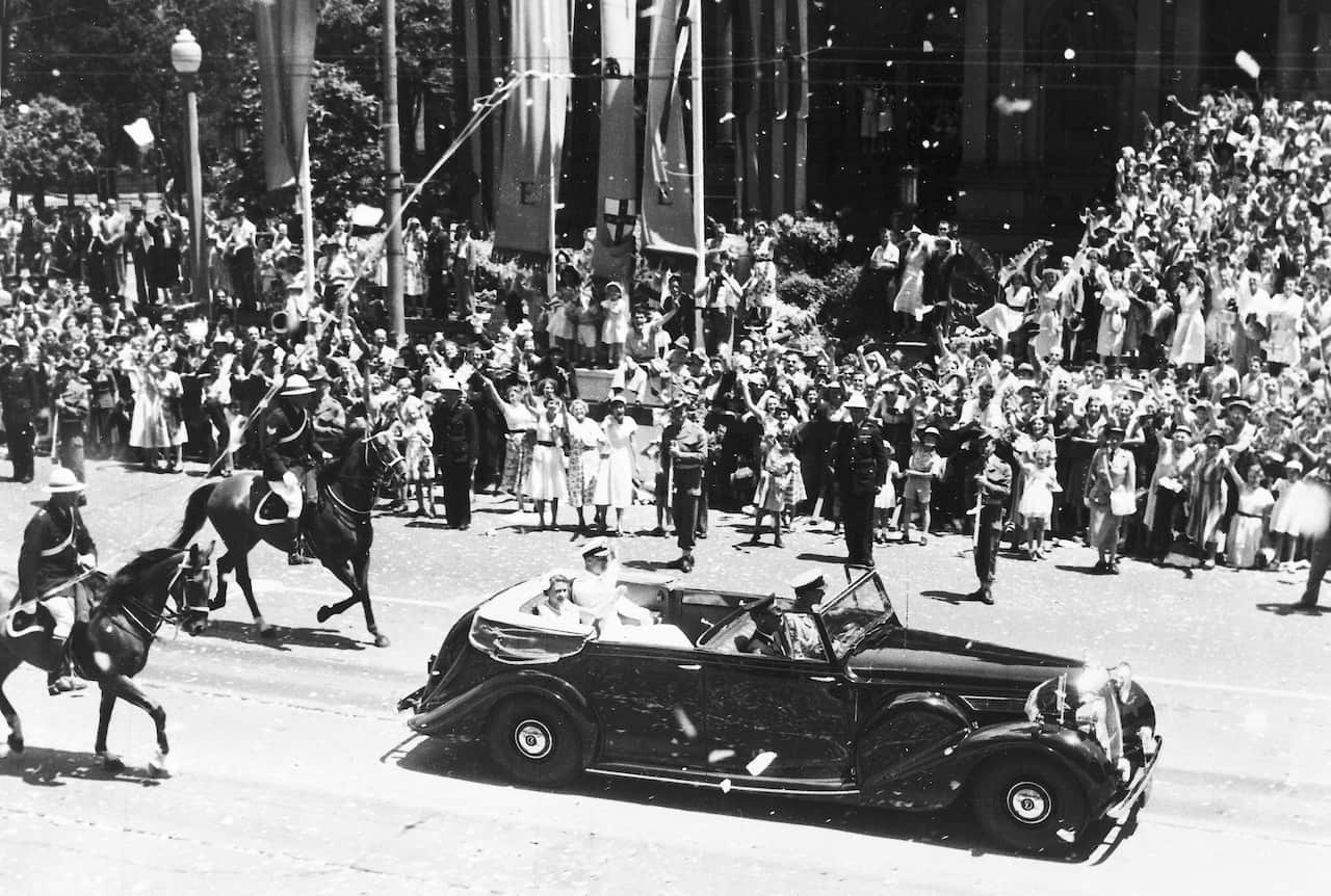 Queen Elizabeth II and Prince Philip in the back of a car driven in front of big crowds in Sydney in 1954.