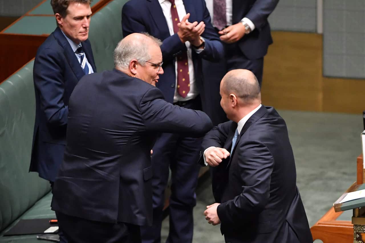 Prime Minister Scott Morrison elbow bumps Treasurer Josh Frydenberg in the House of Representatives last night
