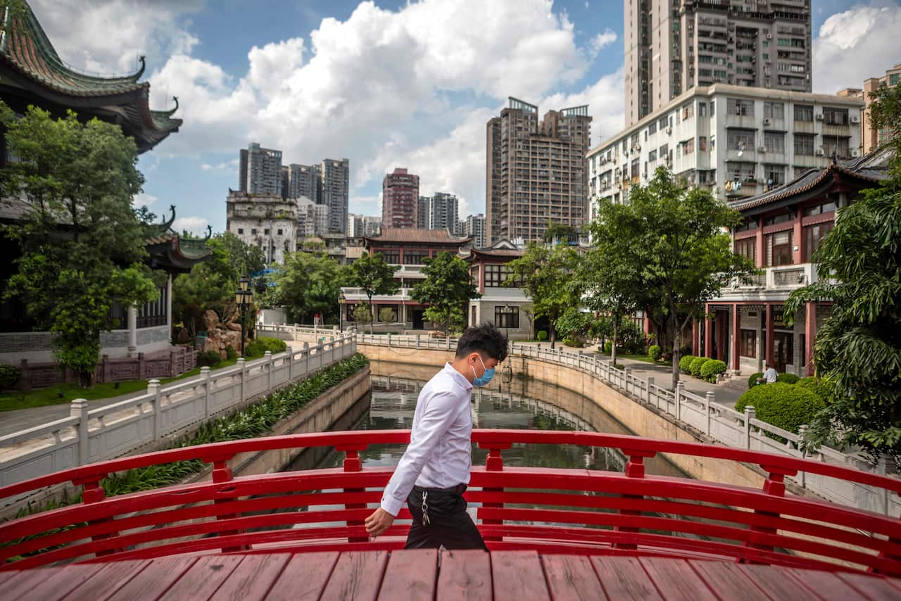 epa08501633 A man wearing a protection mask crosses a bridge in Guangzhou, China, 22 June 2020. China races to contain a second wave of coronavirus cases mostly in Beijing.  EPA/ALEX PLAVEVSKI