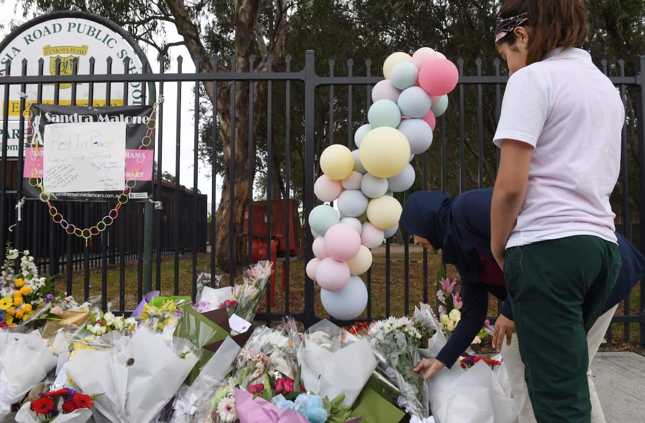 Parents and students place flowers outside the Banksia Road Public School in Greenacre, Sydney, Wednesday, November, 8, 2017 (AAP)