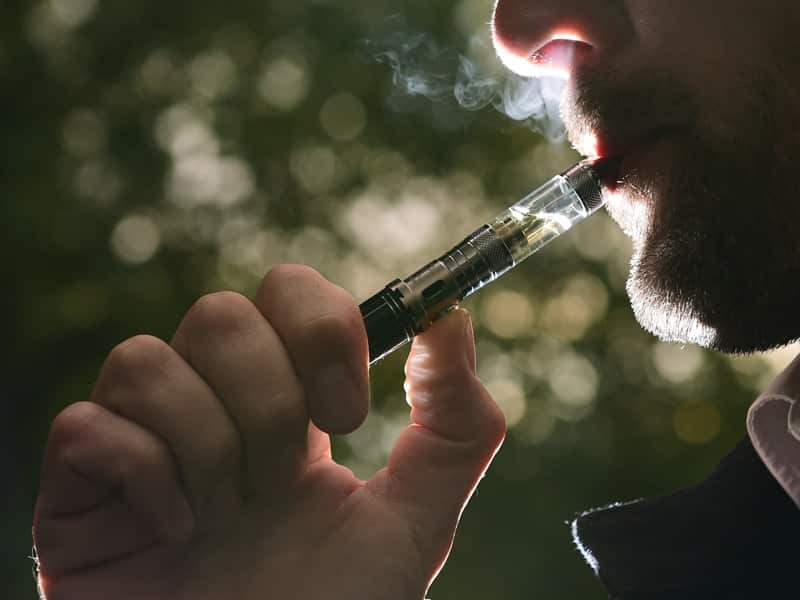 A person smokes from an e-cigarette