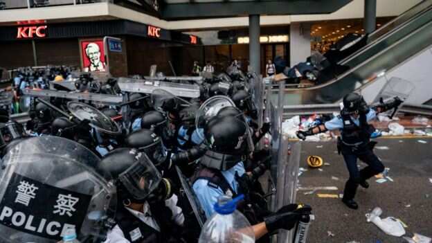 A police officer throws a teargas canister during a protest on 12 June