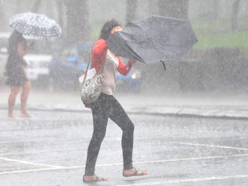 Pedestrians rush across the road during heavy rain in Sydney.