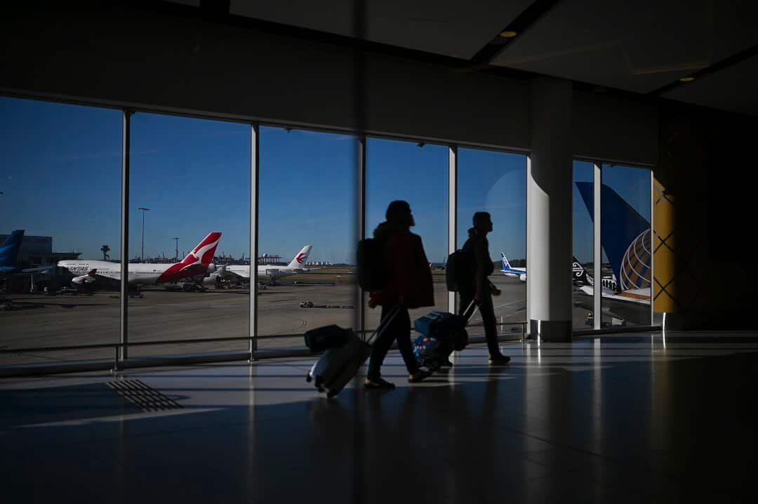A Qantas plane is seen as passengers walk to their flights at Sydney International Airport in Sydney, Wednesday, August 21, 2019. (AAP Image/Lukas Coch) NO ARCHIVING