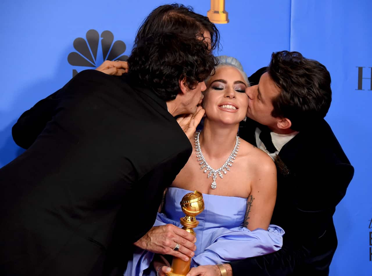 Anthony Rossomando, from left, Andrew Wyatt, and Mark Ronson, right, kiss Lady Gaga, second right, after winning the award for best original song.