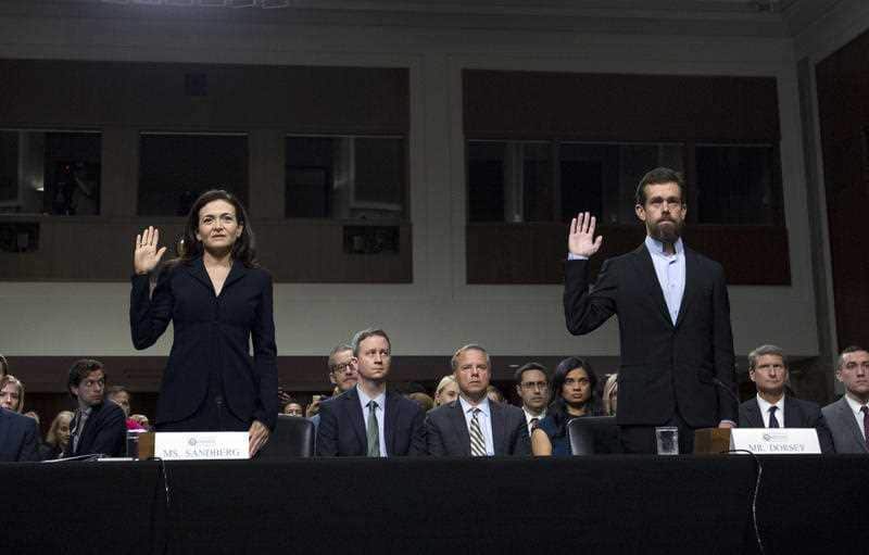 Facebook COO Sheryl Sandberg, left, accompanied by Twitter CEO Jack Dorsey are sworn in before a Senate Intelligence Committee hearing.