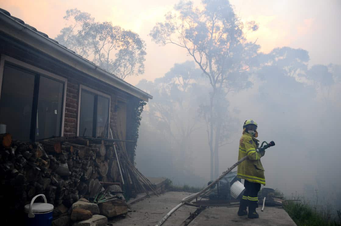 NSW Rural Fire Service and Fire and Rescue NSW personnel conduct property protection as a bushfire burns in Woodford NSW, Friday 8 November, 2019.