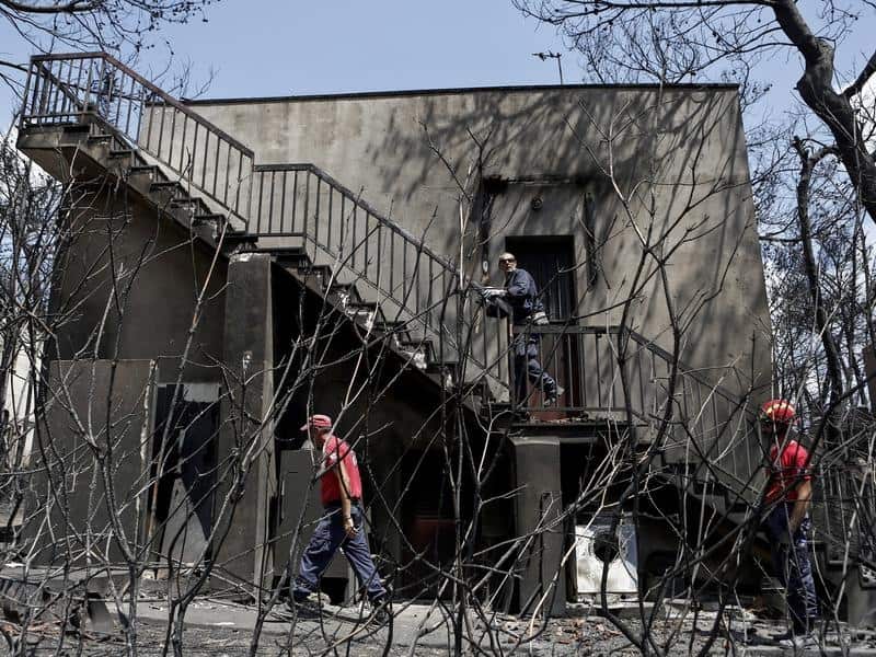 Members of a rescue team search for missing people in a burnt house