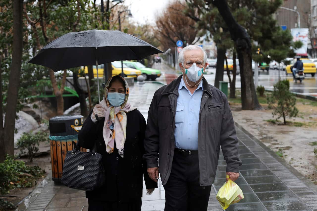 Pedestrians wear masks to help guard against the Coronavirus in downtown Tehran, Iran.