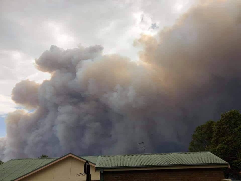 Smoke turns the sky dark over Rev Corkin's property in Moruya.