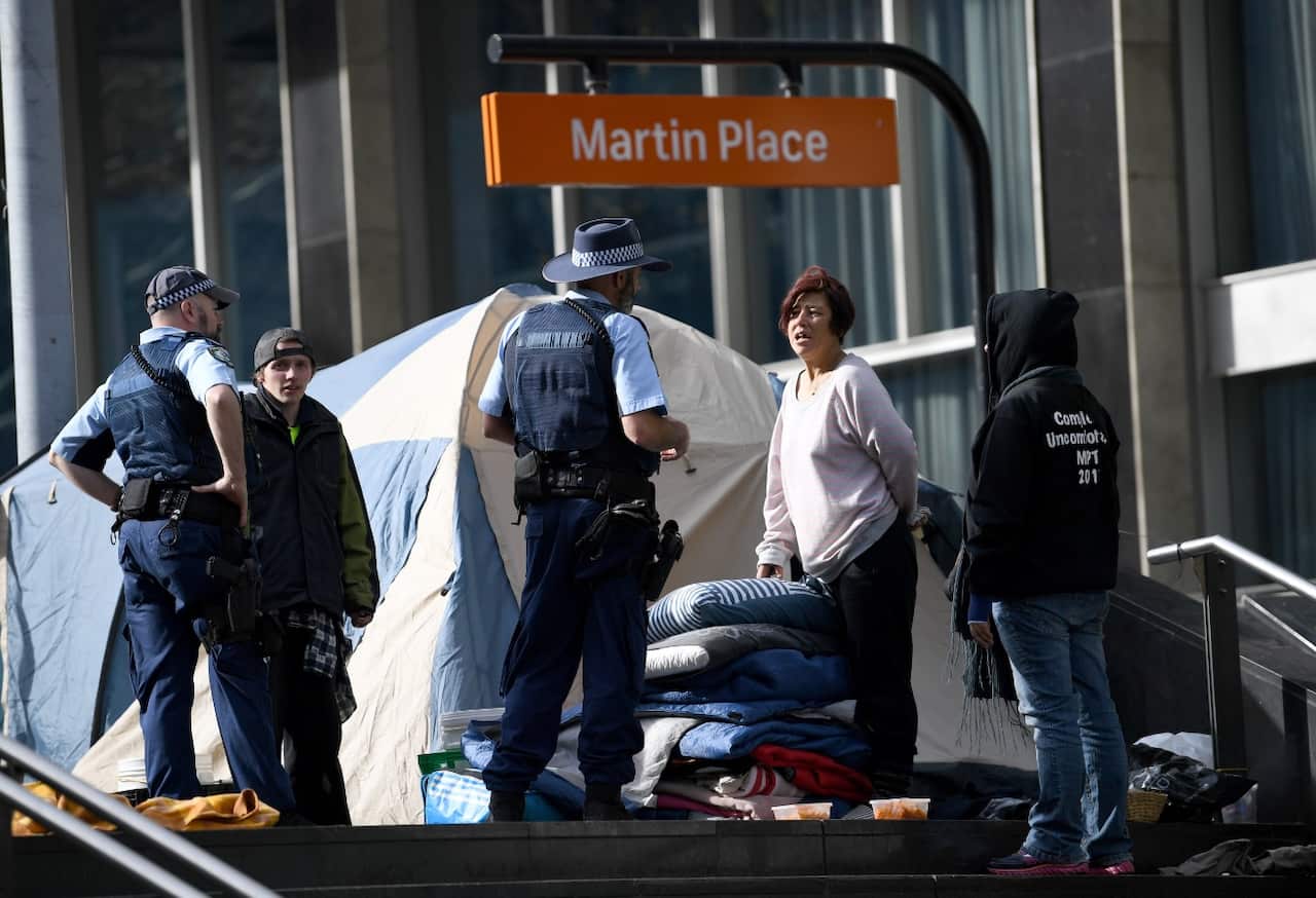 Residents of Tent City speak to the police as they pack their belongings as they prepare to move from Martin Place in Sydney, Friday, August 11, 2017. 