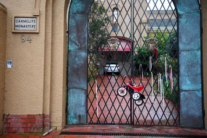 A child's tricycle is seen on the gate of the Carmelite Monastery where Cardinal George Pell stayed in Kew, Melbourne