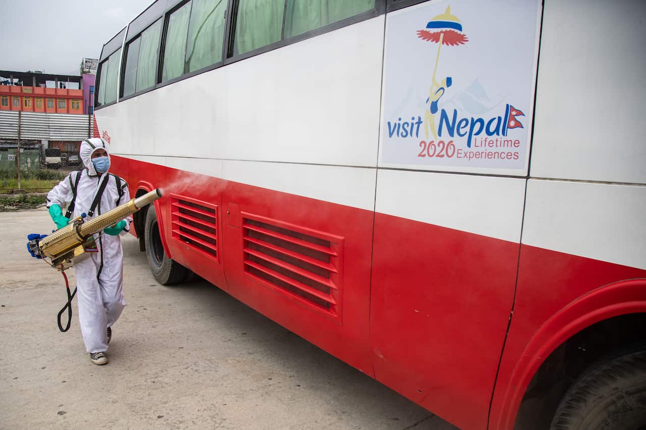 A man dressed in a protective suit sprays disinfectants onto a public bus as a preventive measure against the spread of Coronavirus (COVID-19) in Nepal.
