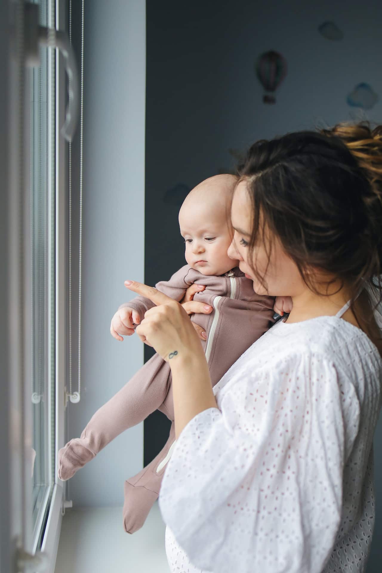 A mother and child standing by the window