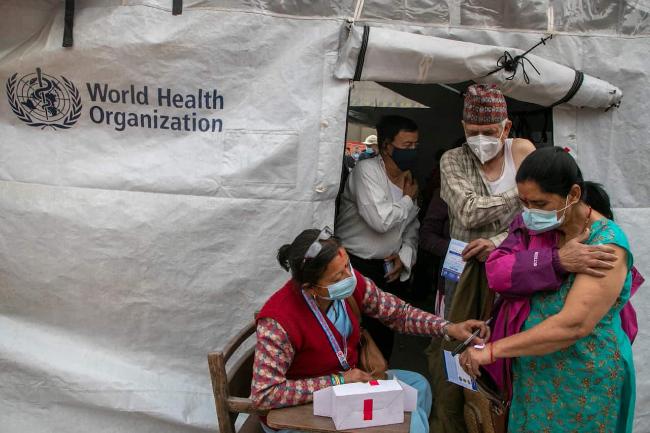 A Nepalese health worker sticks a paper that mentions resting time on the hand of elderly people after they received Covishield COVID-19 vaccine in Kathmandu, Nepal, Sunday, March 7, 2021