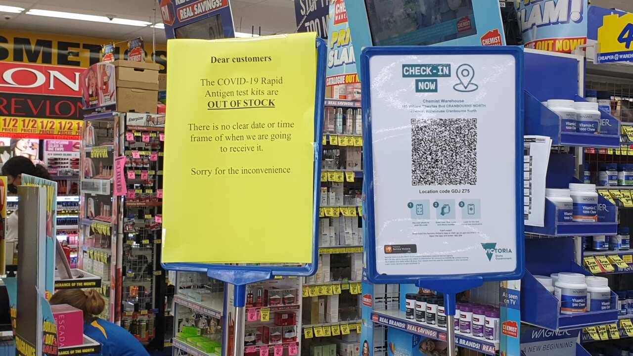 A sign notifying customers of no RAT kits in stock is put up inside a chemist.