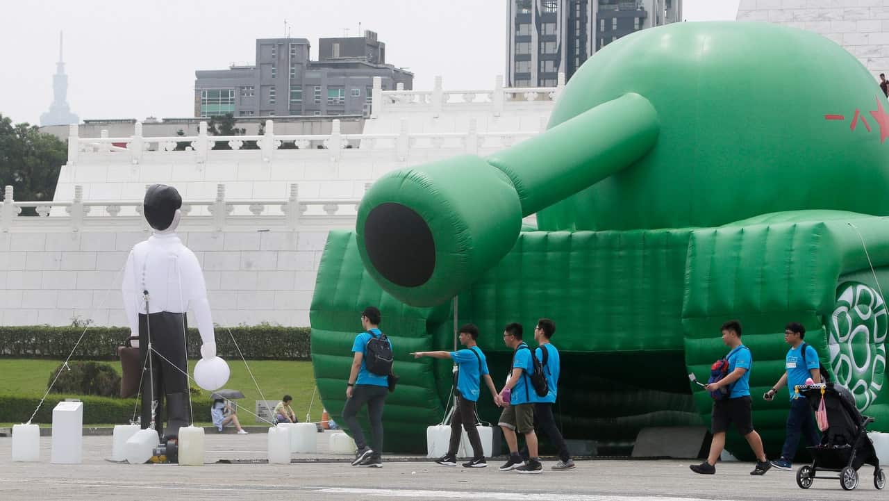 Chinese tourists walk pass the inflatable tank man at the Liberty Square of Chiang Kai-shek Memorial Hall in Taipei, Taiwan.