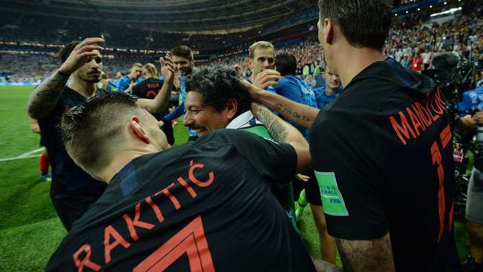 Ivan Rakitic (L) and Mario Mandzukic (R) of Croatia help up photographer Yuri Cortez