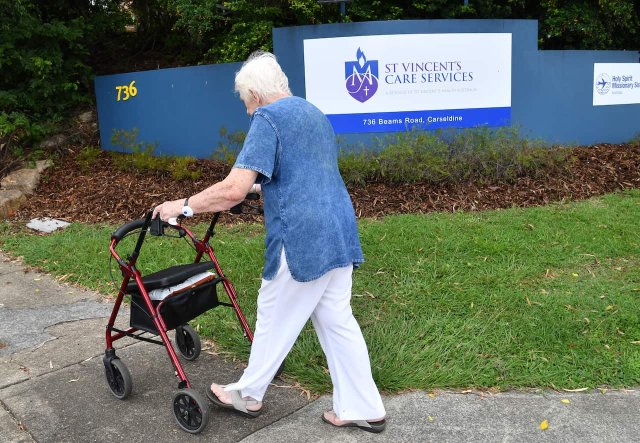 An elderly women is seen walking into the entry of the Holy Spirit Nursing Home