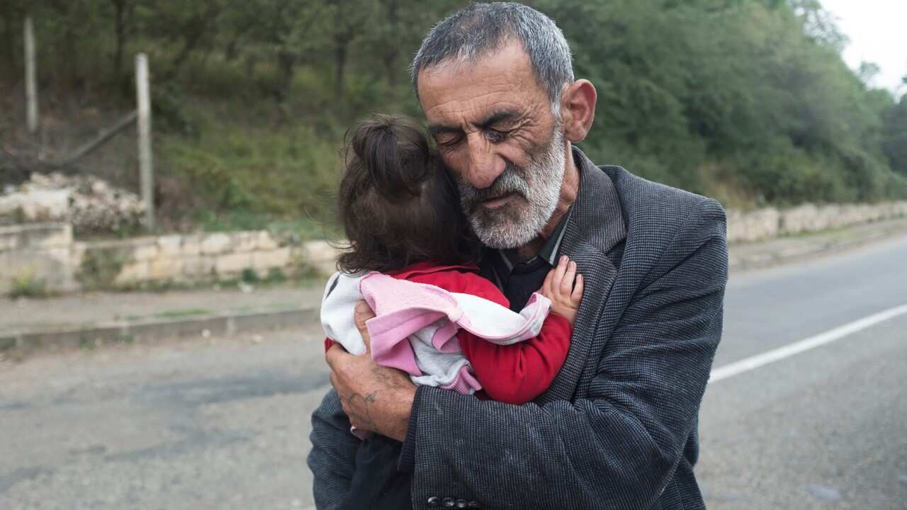 Un uomo costretto ad abbandonare la sua abitazione nella provincia di Hadrut, nel Nagorno-Karabakh, abbraccia sua nipote
