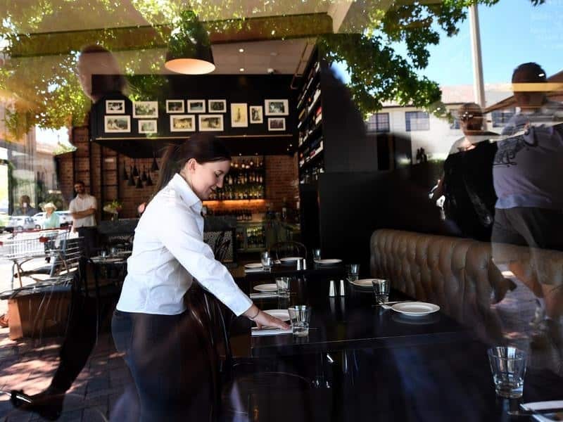 File image of a waiter setting up a table at a restaurant in Canberra.